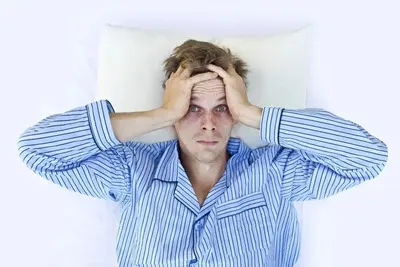 A woman lying awake in bed at night